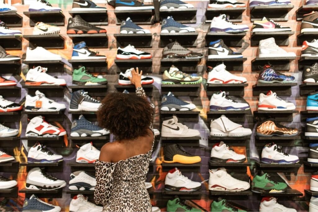 Uma mulher pegando um entre os Diversos sneakers em uma prateleira