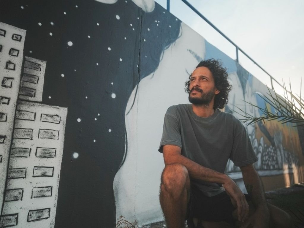 Artista em frente ao mural de Salvador